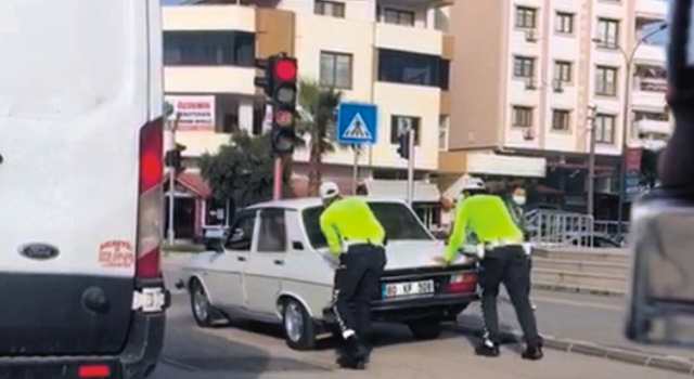 Polisler, yolda kalan sürücüye, aracını iterek yardım etti